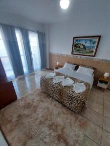 安格拉杜斯雷斯Pousada toca do cambu的一间卧室配有一张豹纹床和地毯。