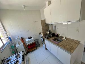 阿拉卡茹Apartamento 3/4 ótima localização的一间带水槽和炉灶的小厨房