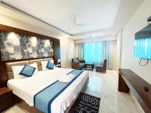 普里Hotel AMBIKA PALACE PURI的一间带大床的卧室和一间客厅