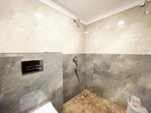 普里Hotel AMBIKA PALACE PURI的带淋浴的浴室(带瓷砖墙)