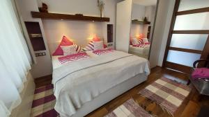 布克福尔多Titi Boutique Apartmanok的卧室配有一张带粉红色枕头的大床