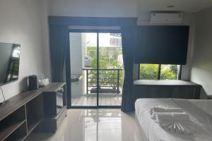 Ban Bo Sai KlangDe Piraya residence的一间卧室设有一张床,并有通往阳台的门