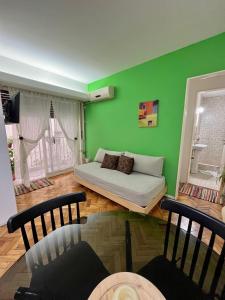 布宜诺斯艾利斯布尔内斯公寓的客厅设有床和绿色墙壁