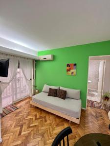 布宜诺斯艾利斯布尔内斯公寓的一间拥有绿色墙壁的卧室和一张位于客房内的床