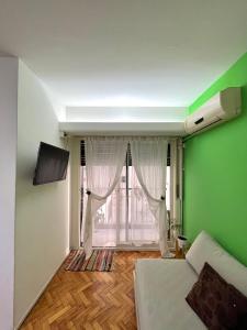 布宜诺斯艾利斯布尔内斯公寓的绿色的客房设有床和窗户。