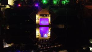 萨利杰尔梅海豚公寓式酒店的一座晚上有紫色灯光的建筑