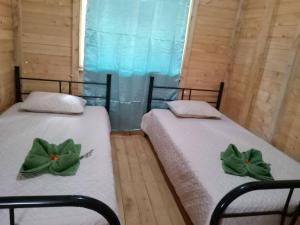 ProvidenciaCabaña Paraíso Verde的两张带绿弓的床
