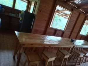 ProvidenciaCabaña Paraíso Verde的一个带凳子的房间里一张大木桌