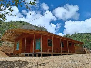 ProvidenciaCabaña Paraíso Verde的田野上带屋顶的木屋