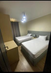 开罗Ocean Blue Luxury serviced Hotel Apartments的配有两张床的酒店客房中的两张床