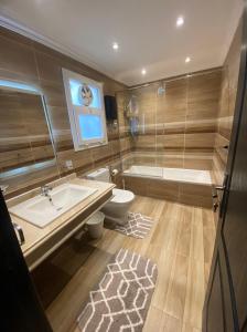 开罗Ocean Blue Luxury serviced Hotel Apartments的带浴缸、盥洗盆和卫生间的浴室