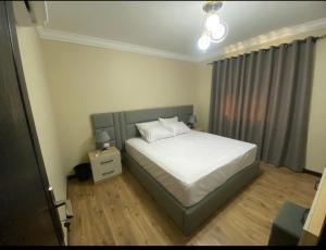 开罗Ocean Blue Luxury serviced Hotel Apartments的卧室配有白色的床和床头柜