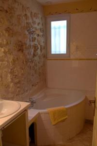 谢瓦布朗克Gîte La Charlette的带浴缸、水槽和窗户的浴室