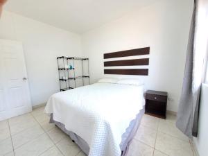 El RosarioCasa Perla ¡Clima y Comfort!的卧室配有白色床和黑白床头板