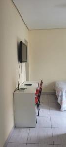 贝洛奥里藏特Kitinet Central的客房设有一张桌子、一台电视和一张床