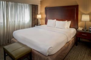 布里奇顿Crowne Plaza Hotel St. Louis Airport, an IHG Hotel的配有一张大床和一部电话的酒店客房