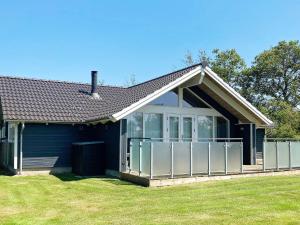 温讷鲁普6 person holiday home in Vinderup的前面有草坪的小蓝色房子
