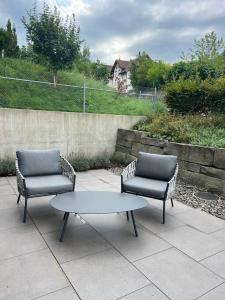 斯特拉德Traumhafte Wohnung am Bodensee的庭院里设有两把椅子和一张桌子
