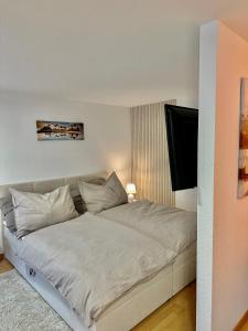 布雷根茨Ferienwohnung zwischen Hafen und Stadt的卧室内的一张带白色床单和枕头的床