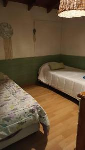 内乌肯Mi casa, tu casa. Entre Plottier y Neuquen.的一间卧室设有两张床,铺有木地板