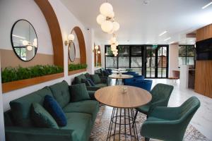 利马Hotel San Blas的客厅配有绿色沙发和蓝色椅子