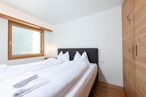 圣莫里茨New! Exclusive Apartment 3min to Chantarella Bahn的窗户客房内的一张大白色床
