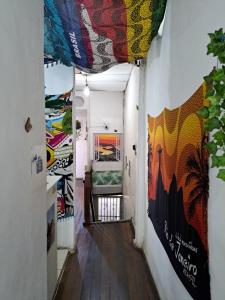 里约热内卢Botafogo Guesthouse的墙上的走廊上装饰着色彩缤纷的艺术作品