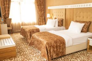 巴库Graaf Hotel的酒店客房设有两张床和窗户。