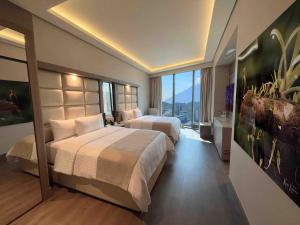蒙特雷Safi Royal Luxury Metropolitan的酒店客房设有两张床和大窗户。