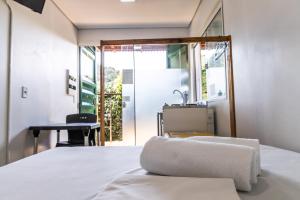 坎布里Praia Camburi - Studios Kuta的一间卧室配有一张床、一张桌子和一面镜子