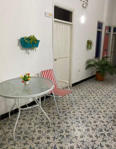 圣玛尔塔Believer Hostel的客房铺有瓷砖地板,配有桌椅。