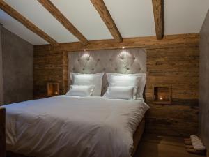 蒂罗尔-基希贝格Kitz Boutique Chalet am Lift的卧室配有一张白色大床和木墙