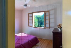 本图贡萨尔维斯Casa aconchegante no Vale Vinhedos的一间卧室设有紫色的床和窗户