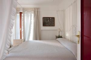 伊斯基亚Villa Gianturco - Luxury In The Green Island的卧室配有白色的床和窗户。
