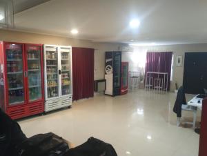 埃塞萨Hostel Bauti en Ezeiza的一间设有红色和白色冰箱以及桌椅的房间
