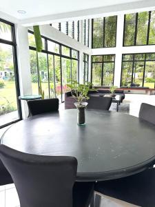 卡兰巴G-HOTEL LUXURY VILLA RESORT AND HOT SPRING的一间带桌椅和窗户的用餐室