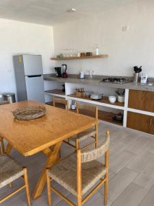 NautlaBoca de agua Villas的厨房配有木桌、椅子和柜台。