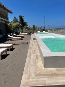 NautlaBoca de agua Villas的海滩旁带长椅的游泳池