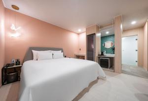 丽水市Browndot Hotel Yeosu Yeocheon的一间带白色大床的卧室和一间浴室