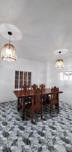 锡朗Country Home in Silang Tagaytay的用餐室配有2张桌子和椅子以及吊灯
