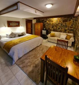 Cabbage Tree CreekBird Songs Getaway Accommodation的一间卧室设有一张大床和石墙