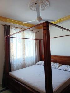 蒙巴萨Mombasa , Kenya 2 bedroom Master Ensuite的一间卧室设有天蓬床和窗户。