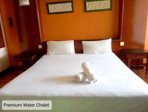 波德申Alpine LXPD Premium Water Chalet的一张白色的床,上面有两条滚毛巾