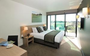 波特西Mercure Portsea & Portsea Golf Club的酒店客房设有一张床和一个大窗户