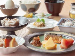 东京Mitsui Garden Hotel Jingugaien Tokyo Premier的餐桌,盘子上放着食物和碗