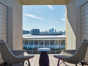 东京Mitsui Garden Hotel Jingugaien Tokyo Premier的市景阳台配有2把椅子和1张桌子