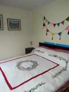 PitrufquénDonde la Euli的一间卧室配有一张带红白毯子的床