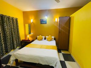 阿姆波尔Samantha Inn Beach Resort的黄色间内一间卧室,配有一张床