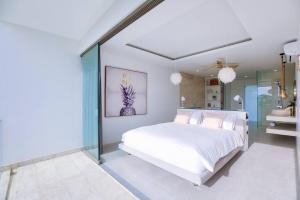 苏梅岛So Paradise Villa 4 bedrooms的卧室设有白色的床和玻璃墙