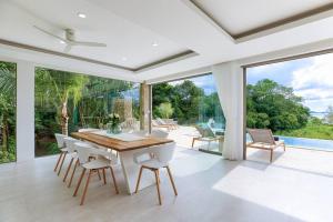 苏梅岛So Paradise Villa 4 bedrooms的白色的用餐室配有木桌和椅子